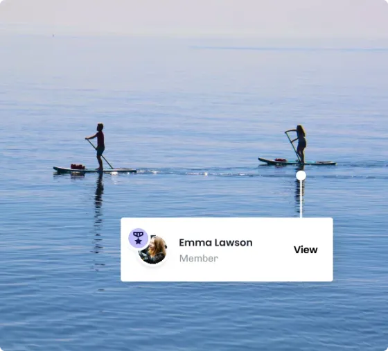 Two paddleboarders on flat open water, with a card marking one of them as a member and a link through to their profile