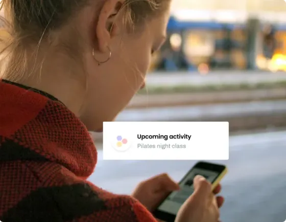 Someone checking their phone outdoors as eola alerts them to an upcoming class