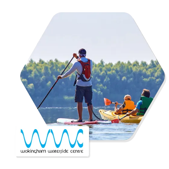 A paddleboarder and two kayakers on the water at Wokingham Waterside Centre, with the centre’s logo